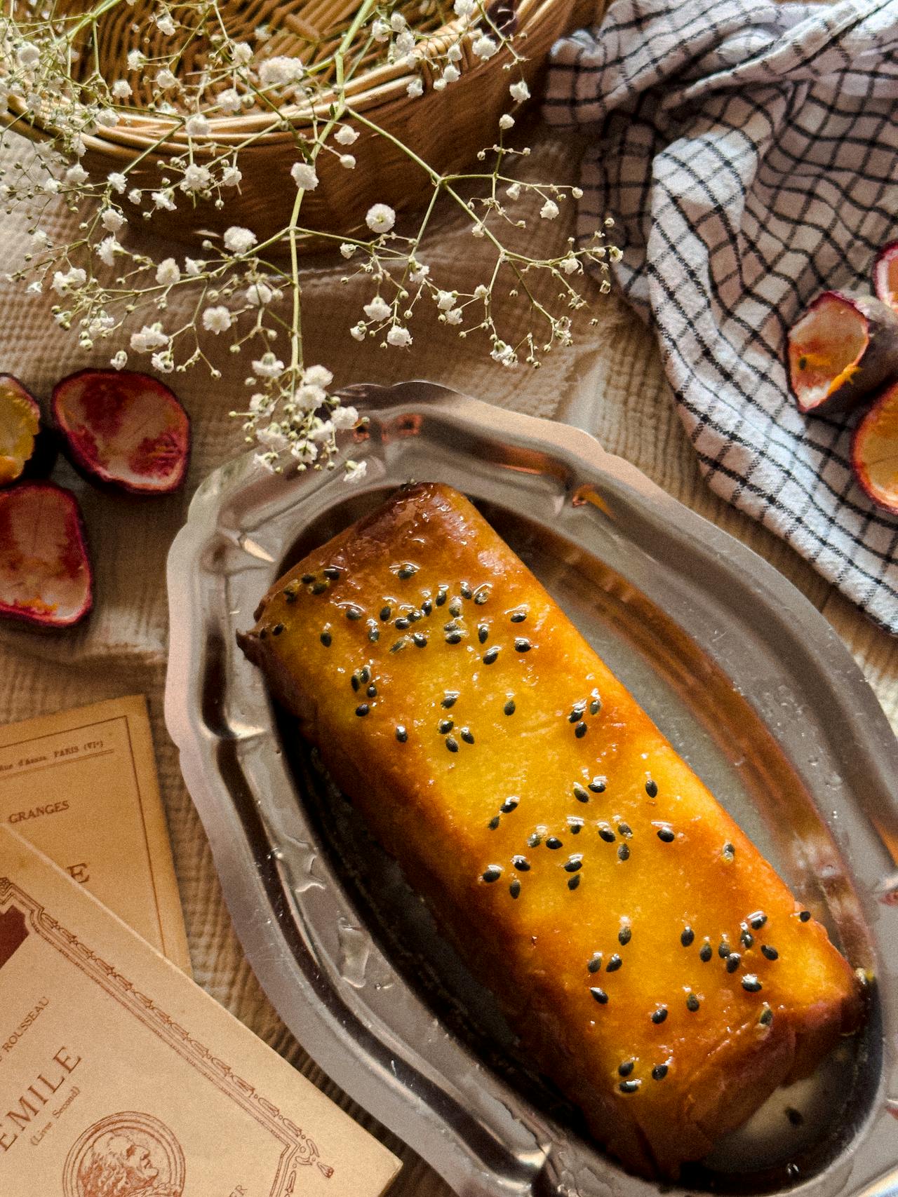Golden passionfruit pound cake sliced on a wooden board with fresh fruit on top